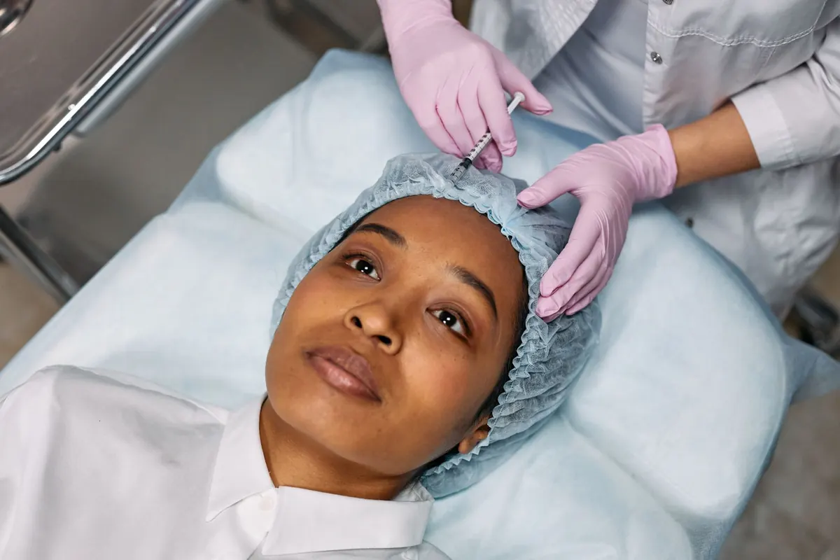 Medical practitioner preparing cosmetic injection for facial rejuvenation treatment