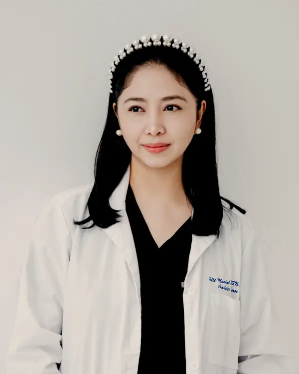 Shelley Mandal, BSN, RN, in her white coat and pearl headband.